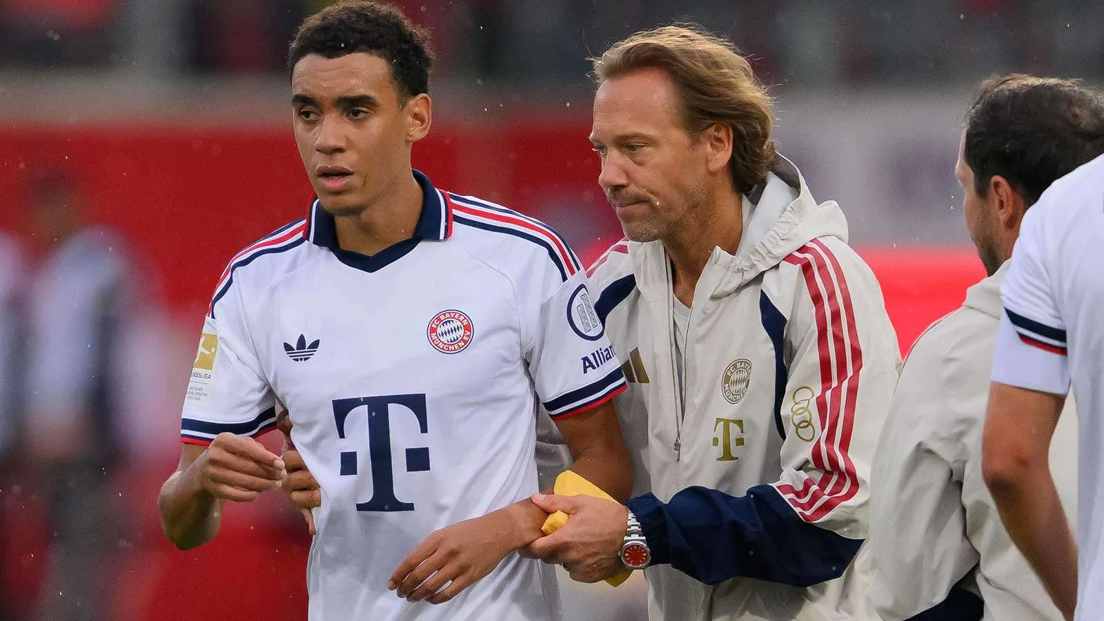 جمال موسيالا لاعب بايرن ميونخ يتلقى الدعم من الطاقم الطبي خلال مباراة، في ظل معاناته من نوبات غياب عصبية مؤقتة.