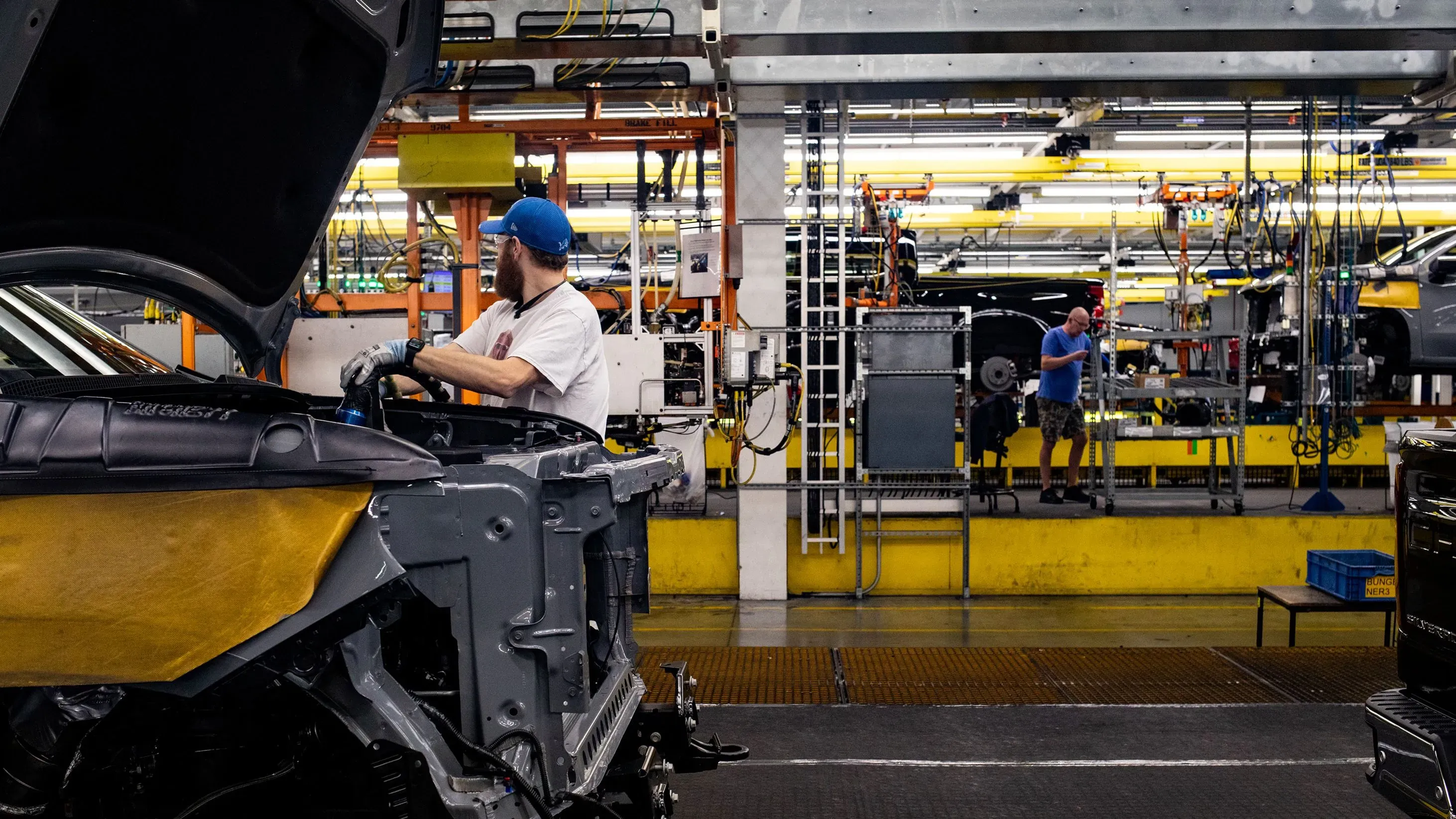 عمال في مصنع جنرال موتورز يقومون بتجميع السيارات، وسط معدات وآلات حديثة، في إطار الاستعداد لعام 2024 وتوقعات الربح.