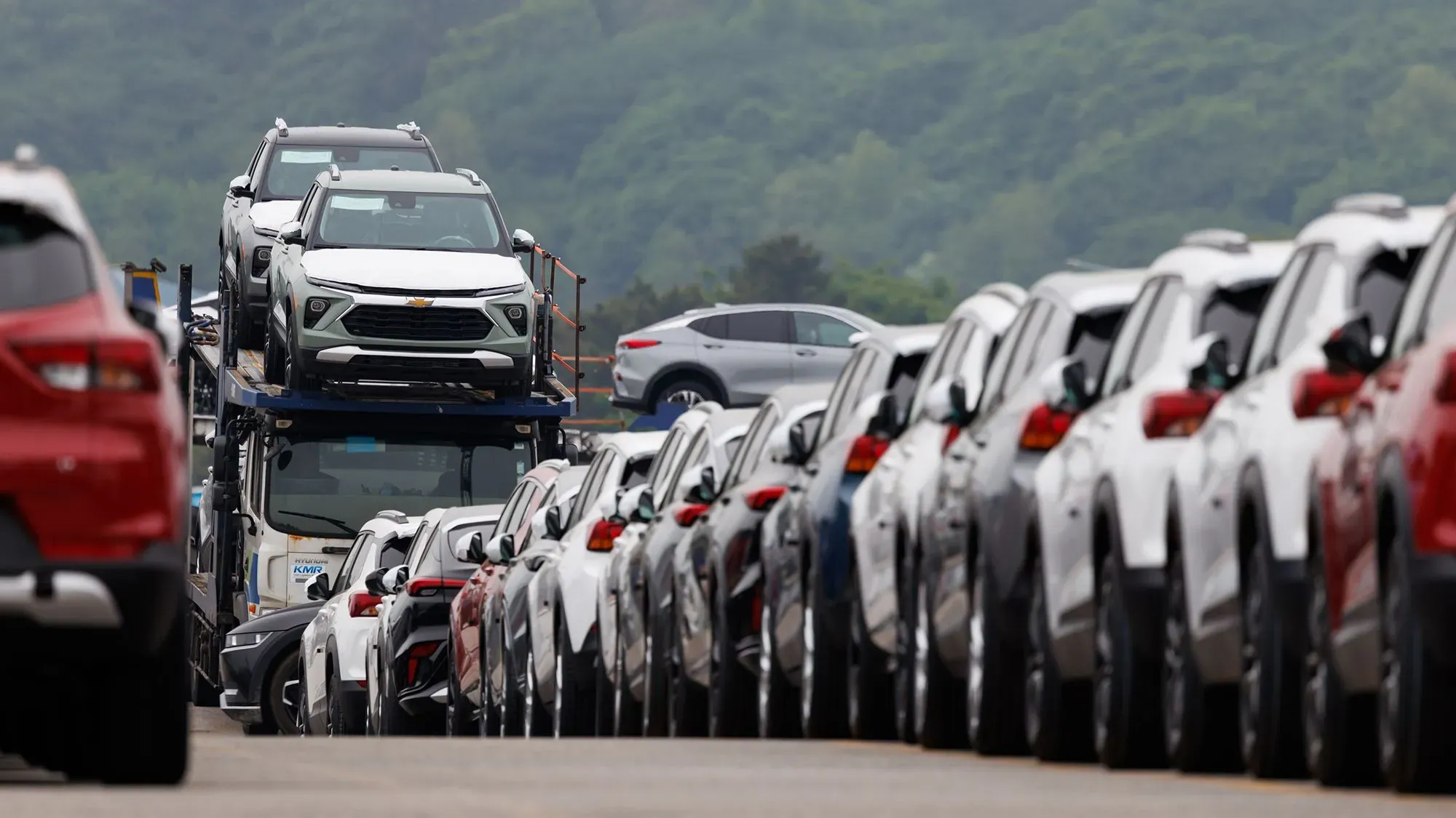 سيارات جديدة من جنرال موتورز مركونة على شاحنة، تعكس تأثير الرسوم الجمركية على صناعة السيارات في الولايات المتحدة.