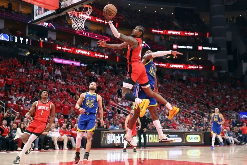 جالين جرين من فريق هيوستن روكتس يسجل نقطة خلال مباراة بلاي أوف ضد غولدن ستايت ووريورز، وسط جمهور متحمس.