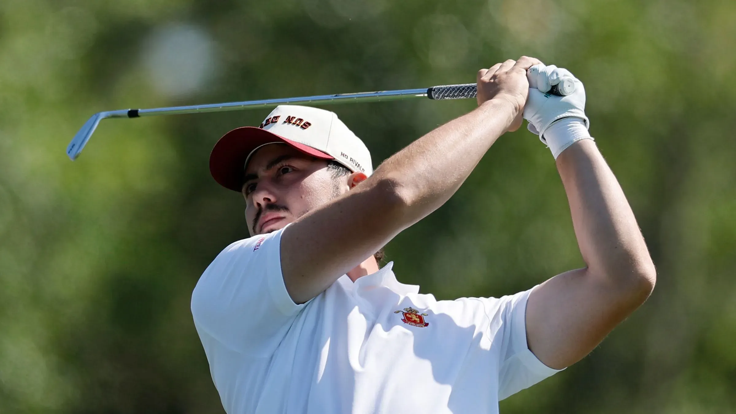 خوسيه لويس باليستر، لاعب غولف شاب، يستعد لضربة في بطولة ماسترز، مرتديًا قبعة تحمل شعار "شياطين الشمس".