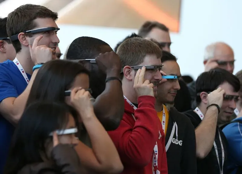 مجموعة من الأشخاص يرتدون نظارات ذكية، يتفاعلون مع التكنولوجيا الحديثة في حدث تقني، مما يعكس اهتمامهم بالابتكارات في مجال الذكاء الاصطناعي.