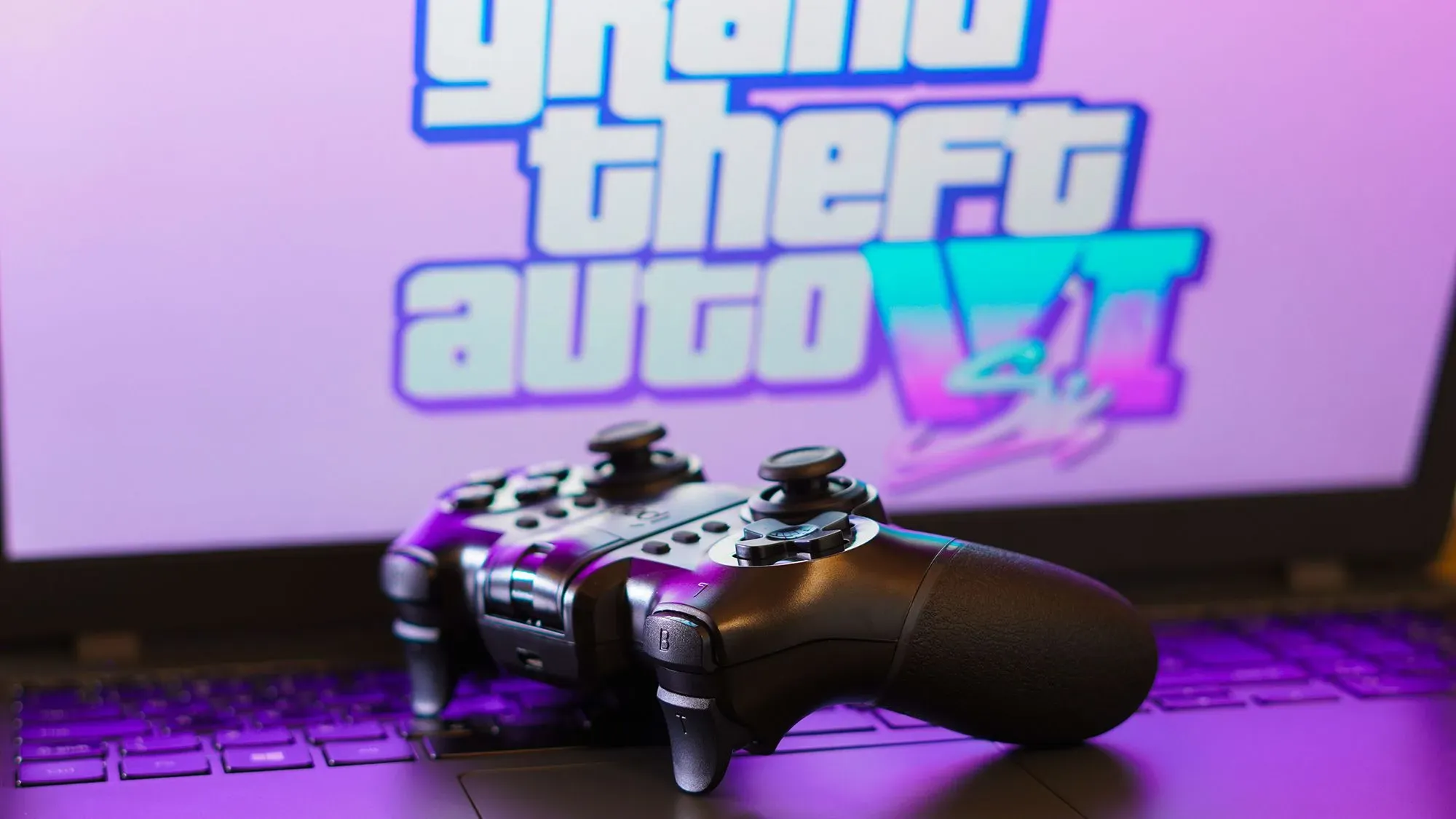 وحدة تحكم ألعاب فيديو أمام شعار "Grand Theft Auto VI" على خلفية ملونة، تعكس انتظار اللاعبين للإصدار الجديد في مايو 2026.
