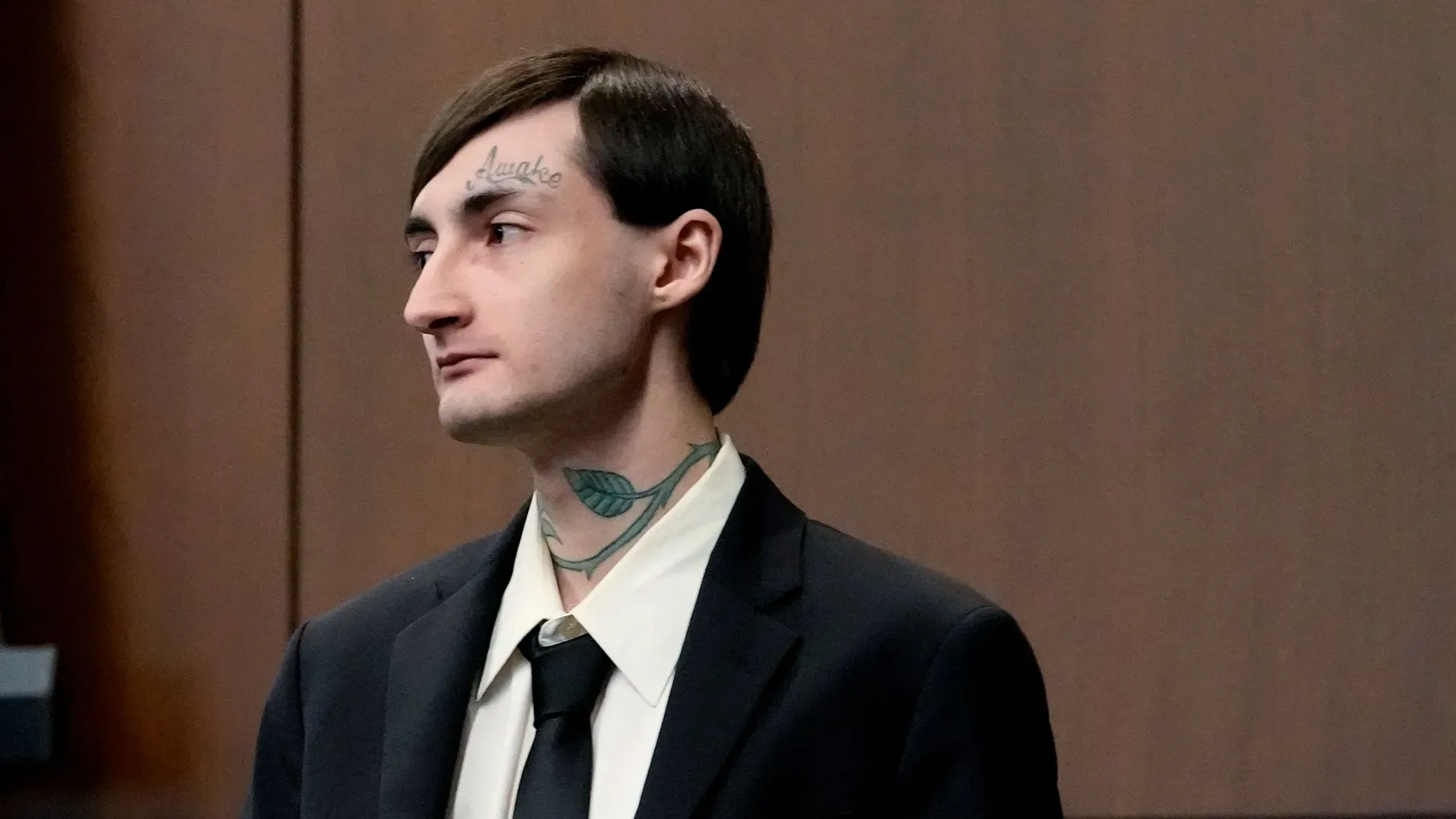 رجل في قاعة المحكمة يرتدي بدلة رسمية، يظهر علامات على وجهه، في سياق محاكمة تتعلق بإطلاق نار جماعي في شيكاغو.