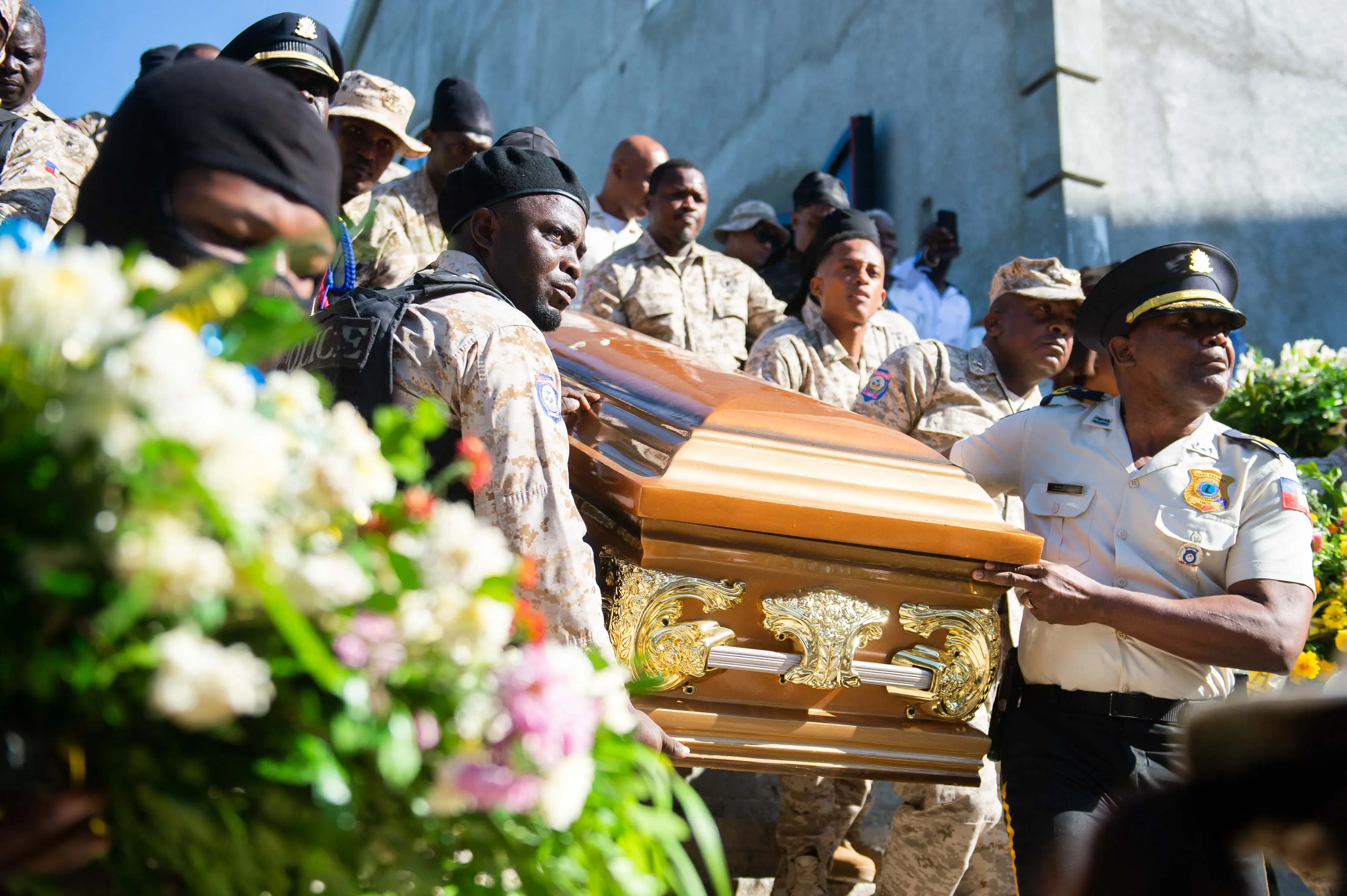 جنود هايتي يحملون تابوتًا خلال جنازة، وسط أجواء من الحزن بسبب العنف المتفشي في البلاد وتأثيره على المجتمع.