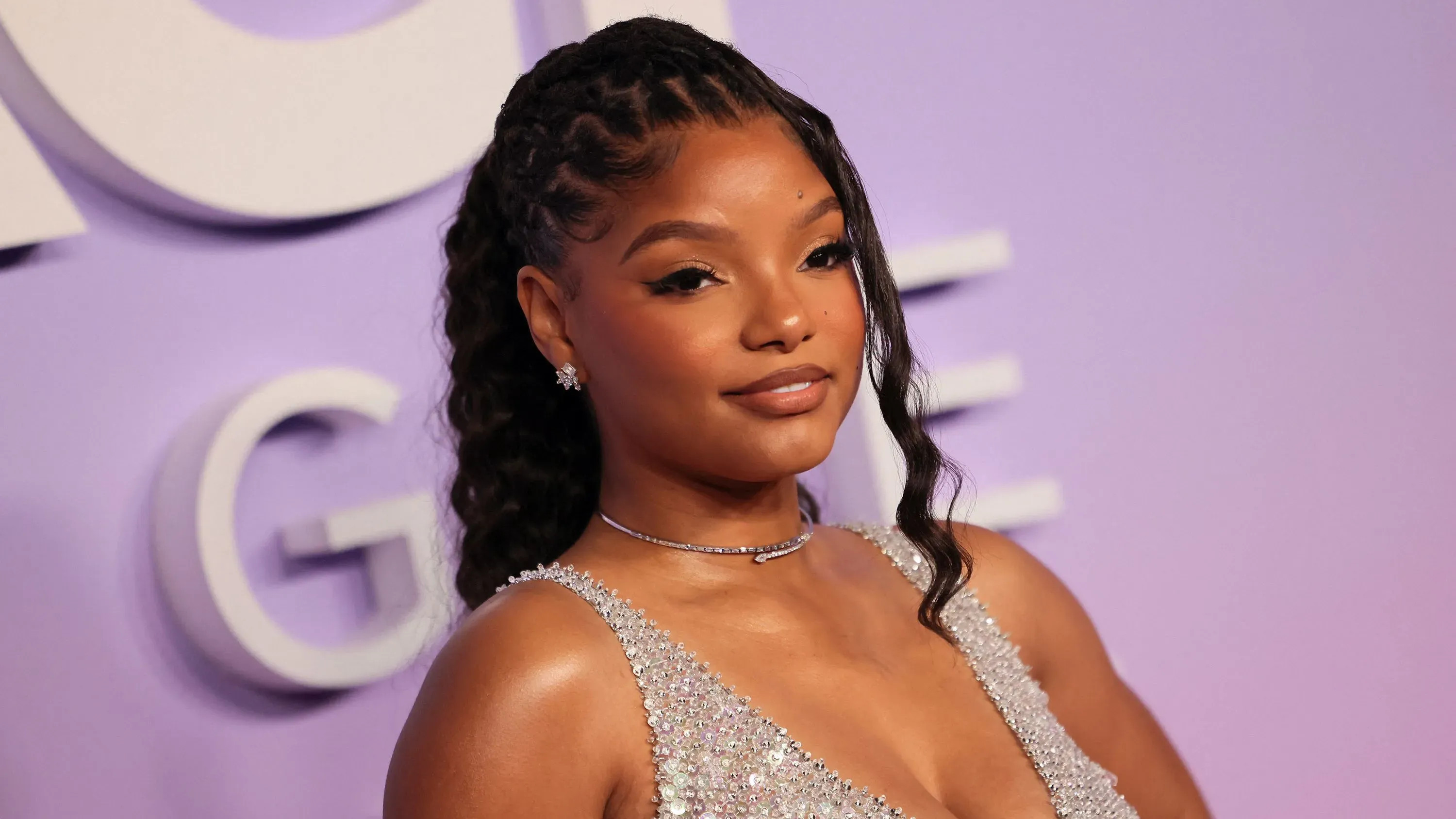 هالي بيلي، الممثلة والمغنية، تظهر في حدث رسمي، مع تسريحة شعر مميزة وفستان أنيق، تعكس شخصيتها القوية في ظل الظروف الصعبة.