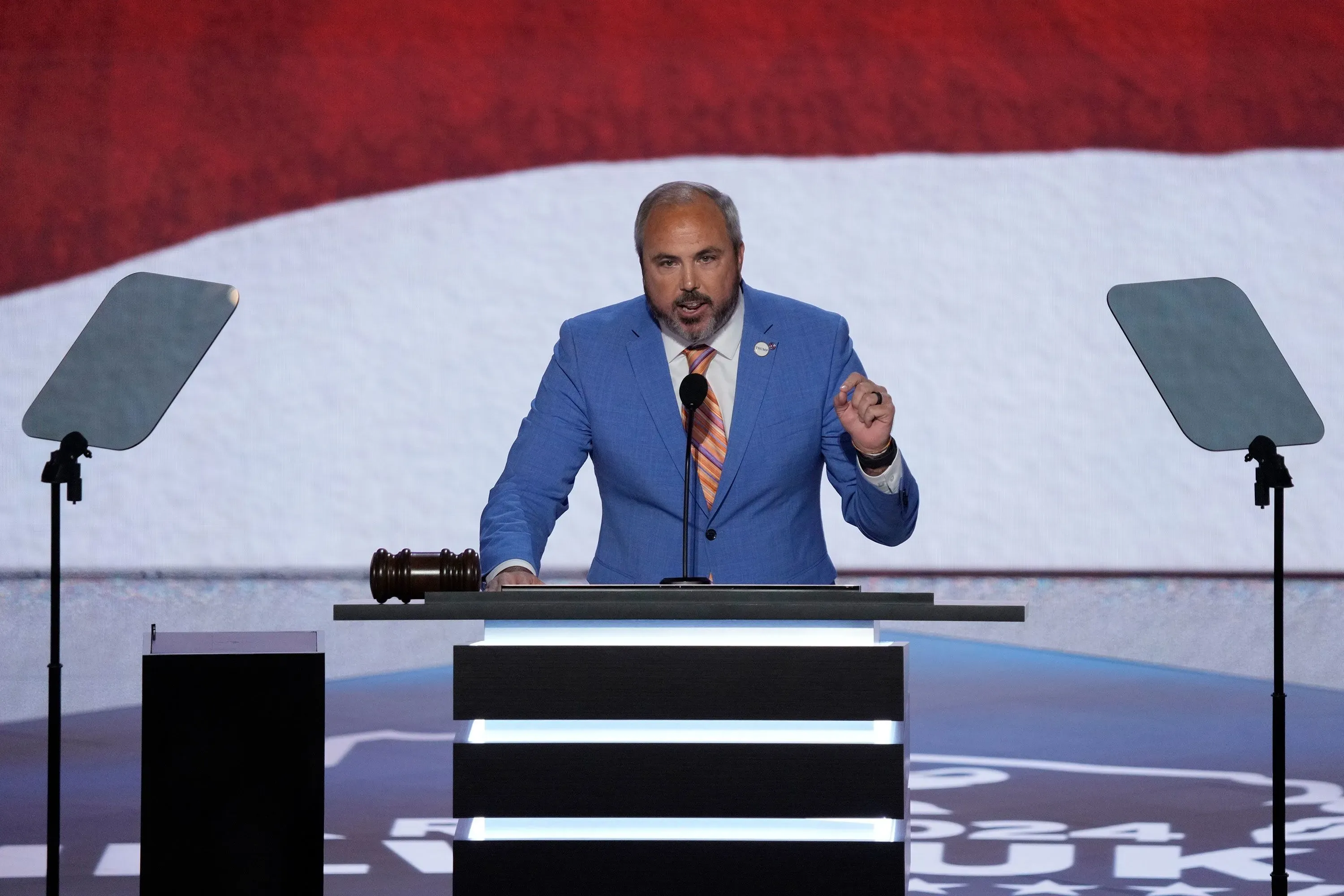 جو جروتيرز يتحدث على المنصة خلال مؤتمر الحزب الجمهوري، مع العلم الأمريكي خلفه، مؤكدًا دعمه للرئيس ترامب.