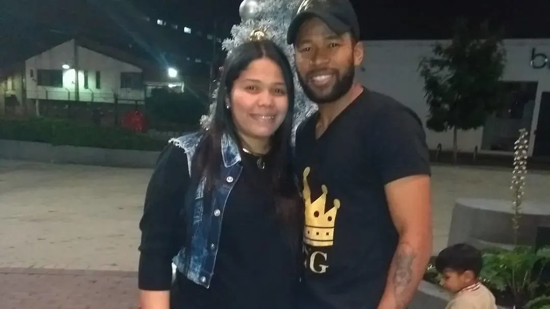 صورة لجيرسي رييس مع صديقته، حيث يظهر رييس مبتسمًا ويرتدي قميصًا أسود مزين بتاج، مع خلفية حضرية.