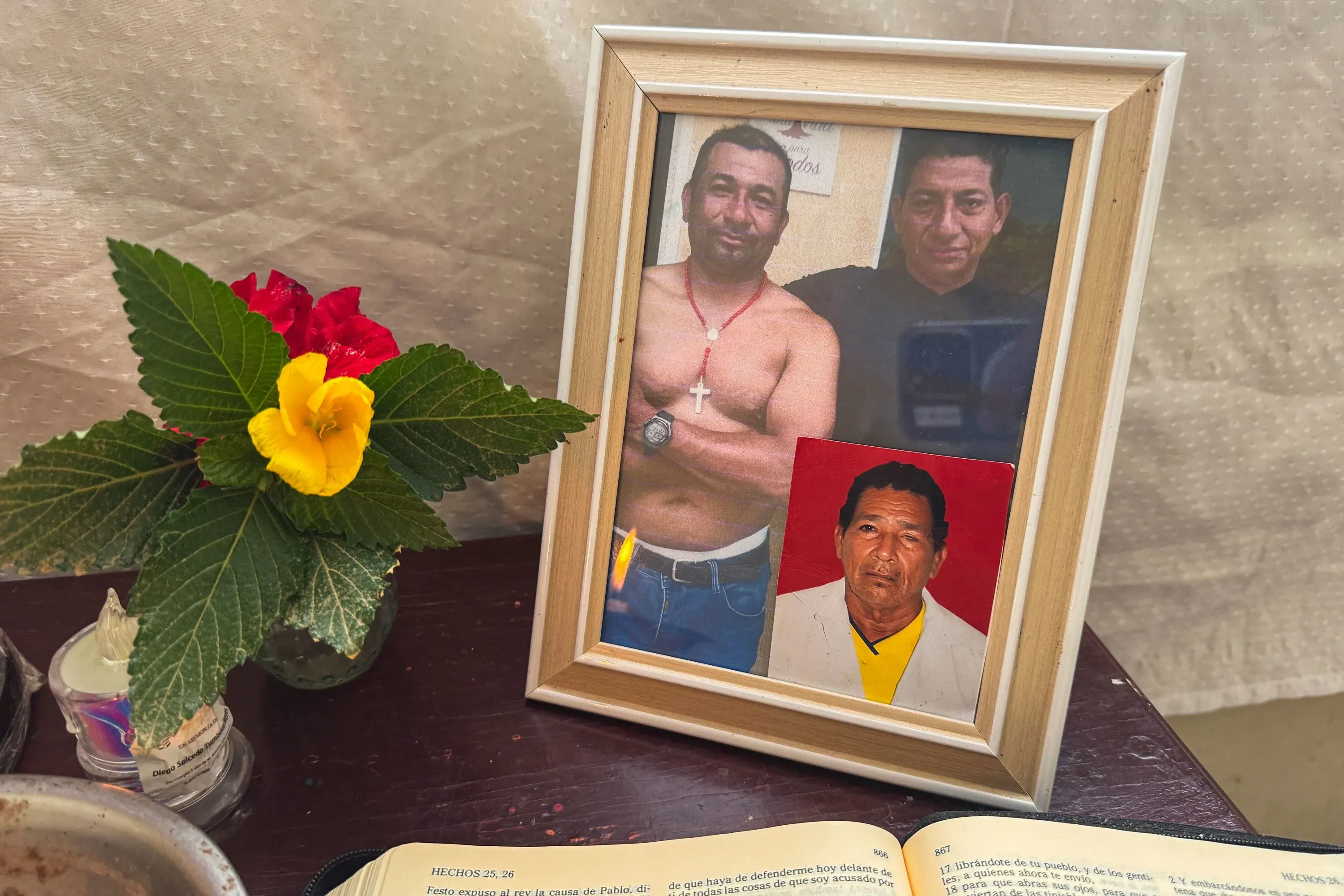 إطار يحتوي على صورتين لرجلين، أحدهما عاري الصدر، وصورة أخرى لرجل مسن، مع زهور ملونة في المقدمة وكتاب مفتوح.