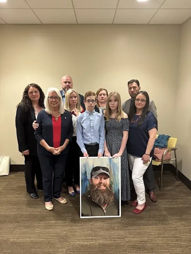 عائلة بيلكي تتجمع حول صورة له، تعبيراً عن الحزن والدعم بعد استخدام الذكاء الاصطناعي لإعادة تمثيل أقواله في المحكمة.