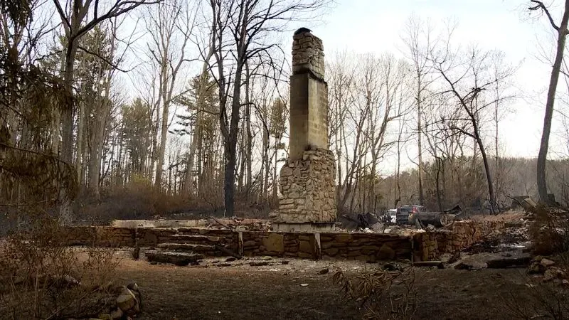 صورة تظهر بقايا "كوخ الأمل" المدمر في نورث كارولينا، حيث تبقى المدخنة قائمة وسط آثار حرائق الغابات الأخيرة.