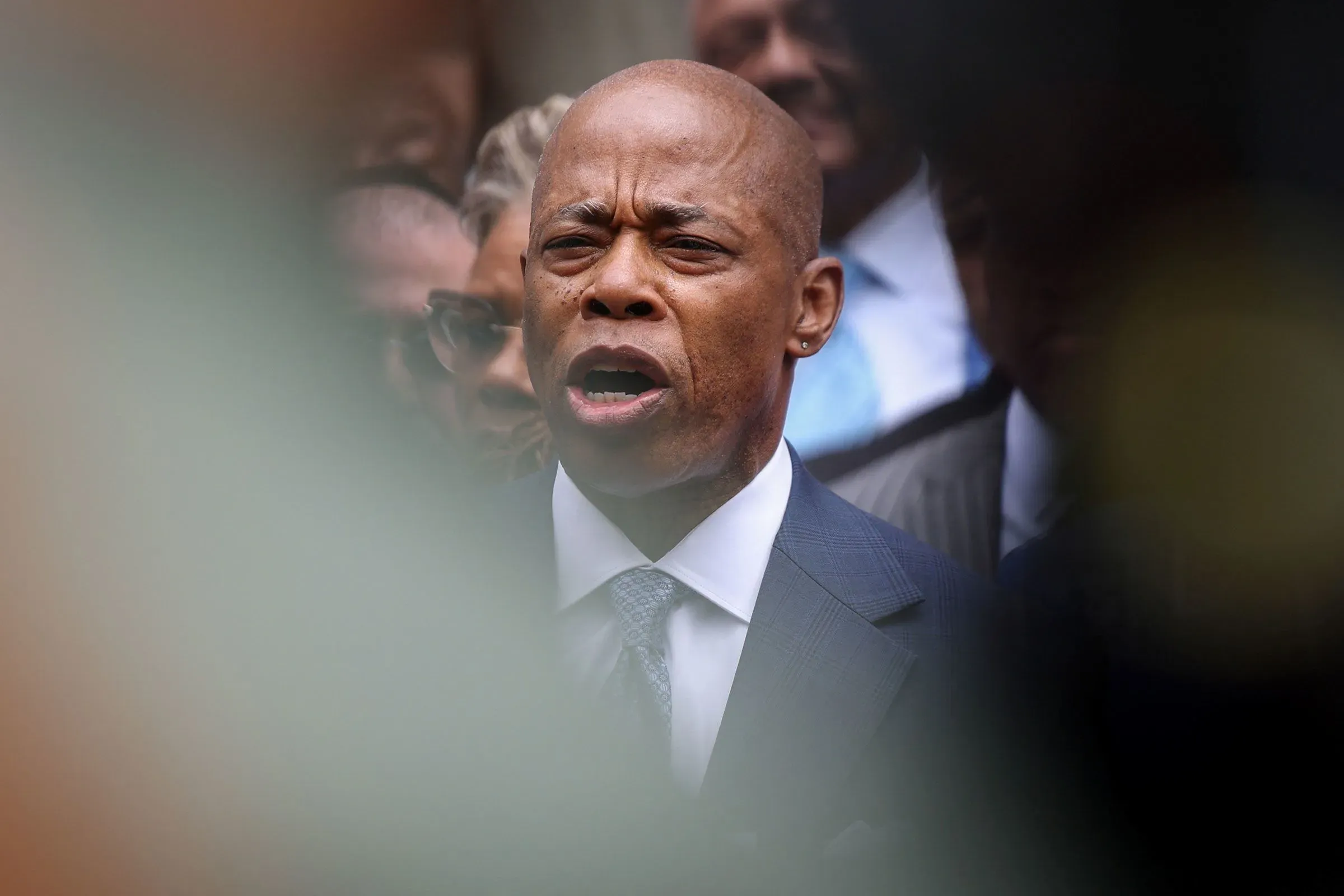 إريك آدامز، عمدة نيويورك، يتحدث بحماسة خلال مؤتمر صحفي، وسط حشد من المؤيدين، مع التركيز على قضايا السلامة العامة.