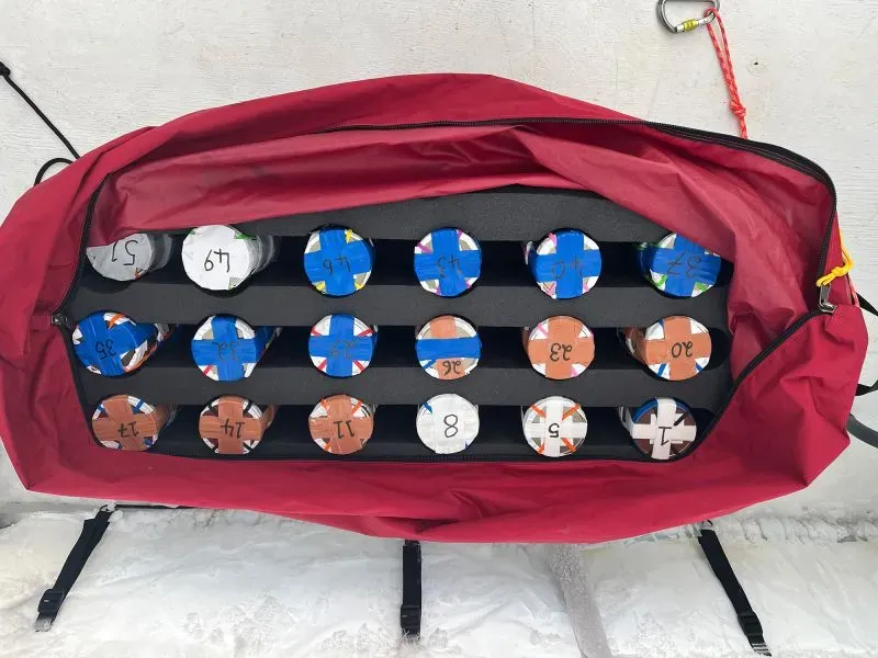 زلاجات محملة بالعينات من الثلوج، مرتبة داخل حقيبة حمراء، لجمع بيانات عن اللدائن الدقيقة في القارة القطبية الجنوبية.