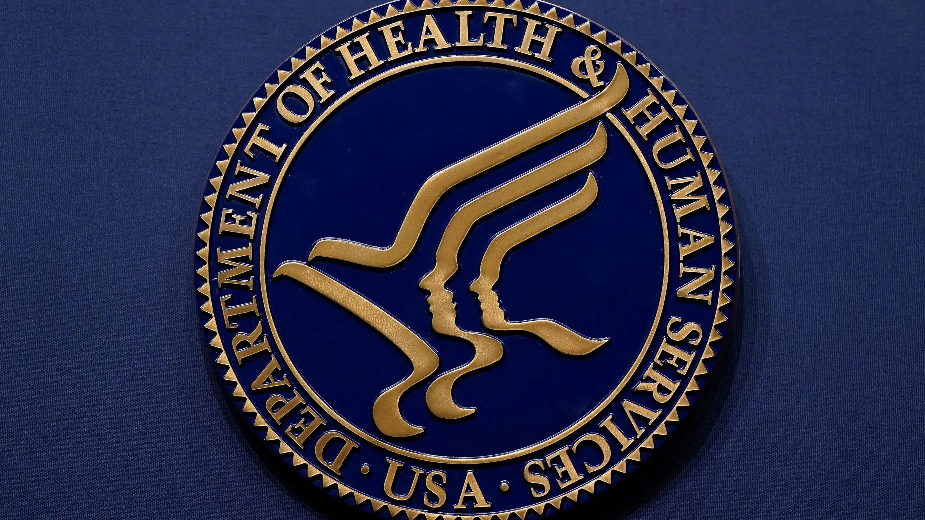 شعار وزارة الصحة والخدمات الإنسانية الأمريكية، يرمز إلى جهود تطوير لقاح عالمي للإنفلونزا لحماية من سلالات متعددة.