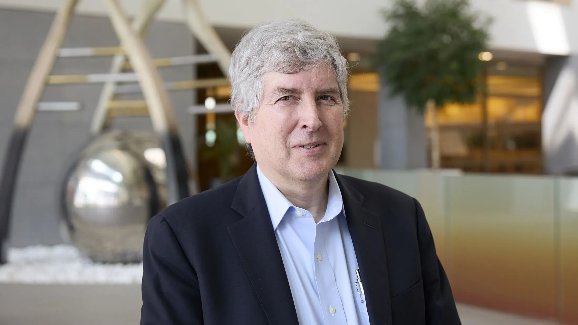 الدكتور فيليب دورميتزر، مسؤول تنفيذي سابق في فايزر، يقف في مكتب معاصر، وسط تحقيقات حول تأخير لقاح كوفيد-19.