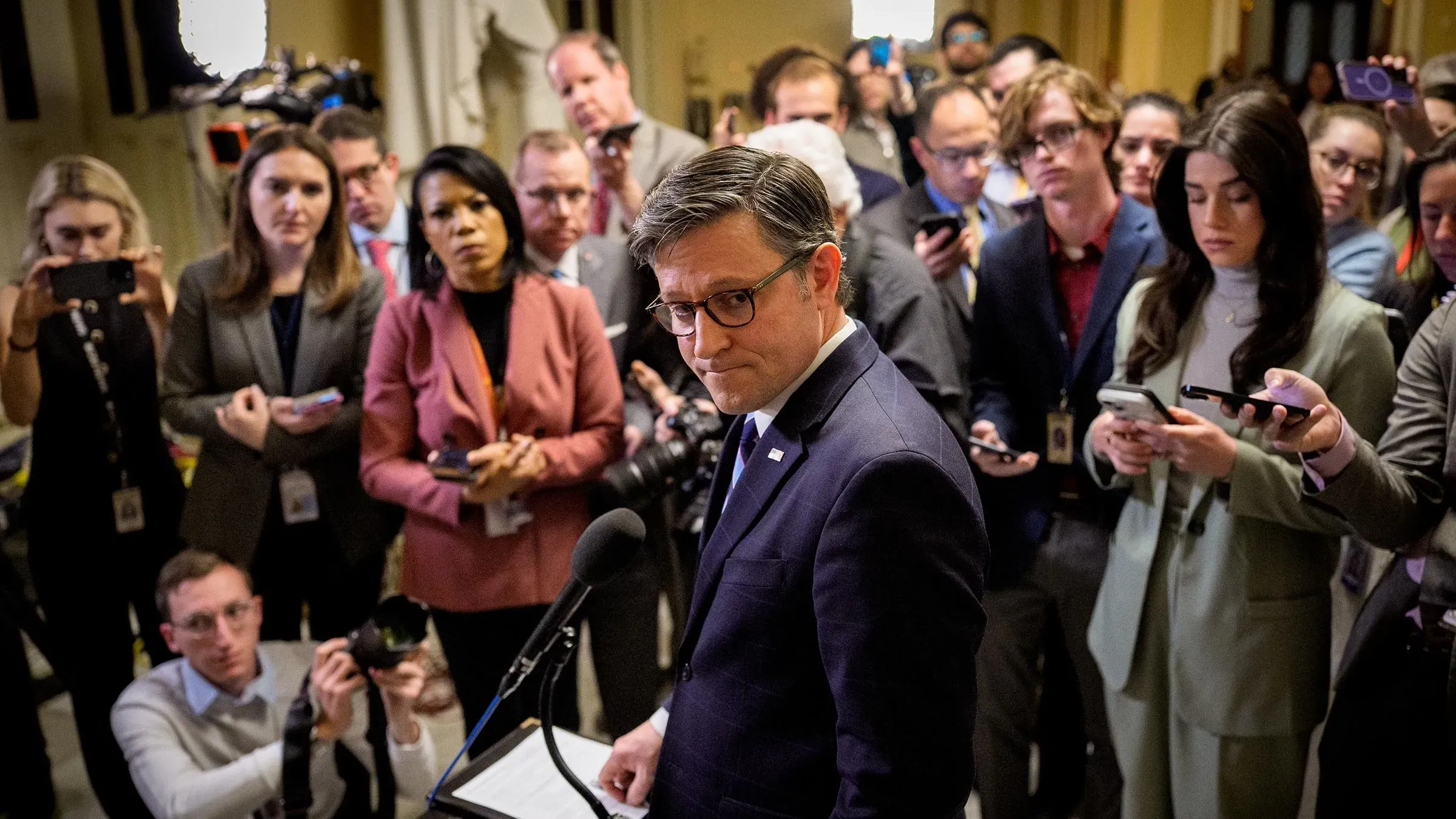 مؤتمر صحفي في الكابيتول هيل، حيث يتحدث مسؤول أمام حشد من الصحفيين، مع تركيز على تفاصيل مشروع قانون الدفاع وأمن الحدود.