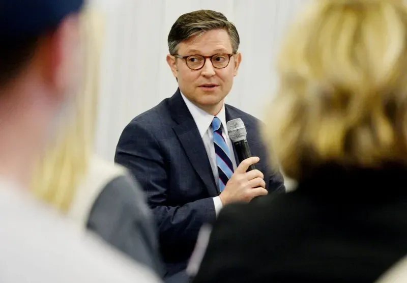 رجل يرتدي بدلة يتحدث إلى جمهور، مع التركيز على قضايا الرعاية الصحية وتأثير تخفيضات برنامج Medicaid على الناخبين.