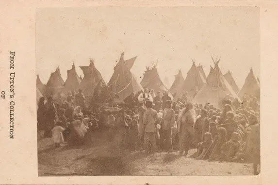 مجموعة من الأشخاص يجلسون أمام خيام تقليدية، مع وجود شخصيات بارزة في المقدمة، تعكس تاريخ الشعوب الأصلية في أمريكا.