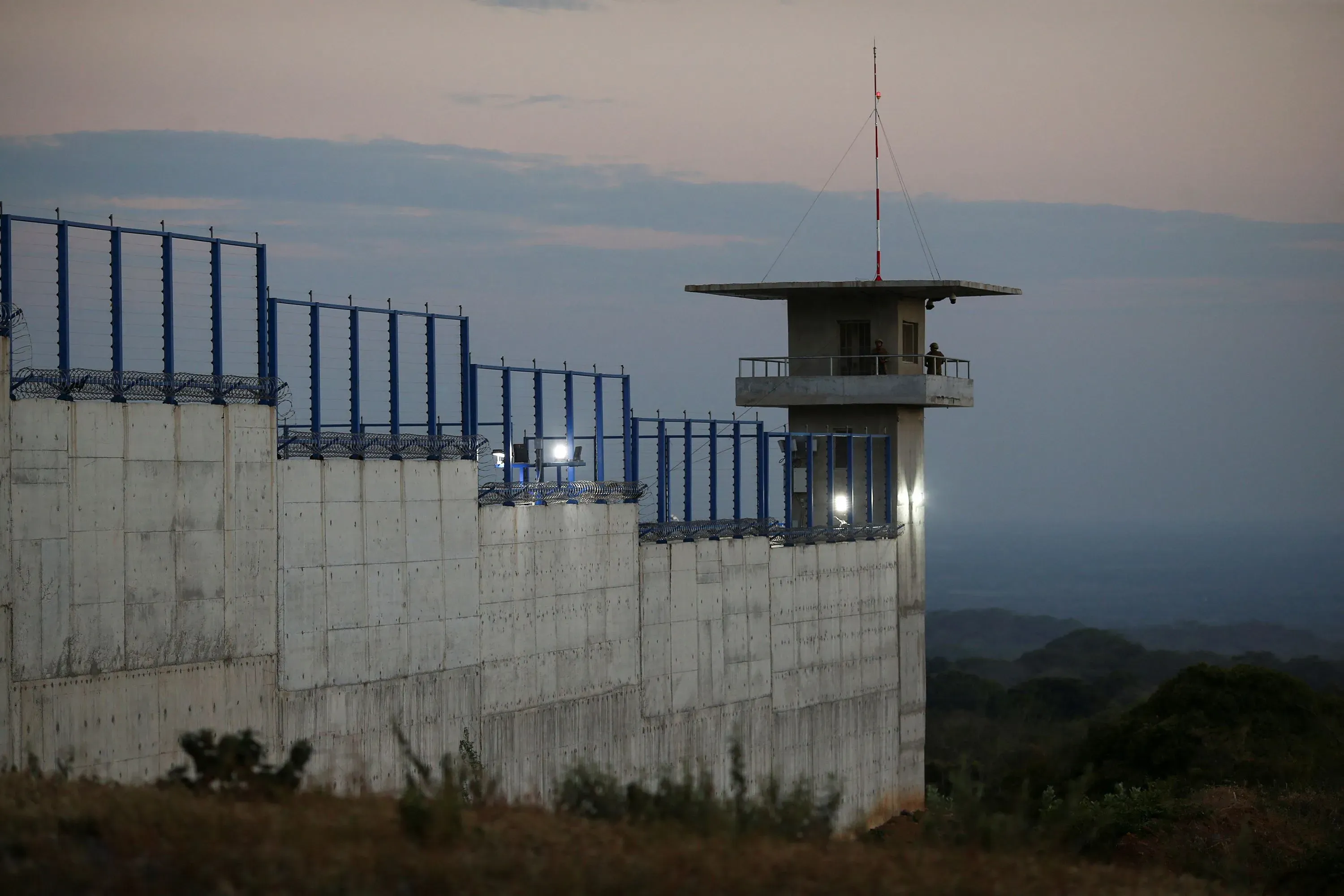 جدار سجن سيكوت في السلفادور مع برج حراسة، يظهر الأجواء القاسية للاحتجاز الذي تعرض له المهاجرون الفنزويليون.