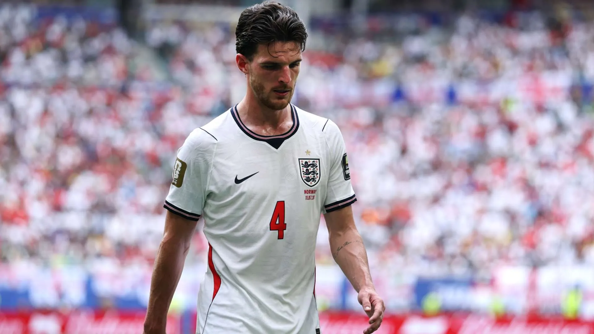 لاعب كرة قدم إنجليزي يرتدي قميص منتخب إنجلترا رقم 4 خلال مباراة في كأس العالم، يعكس تركيزه وإرهاقه في الملعب.