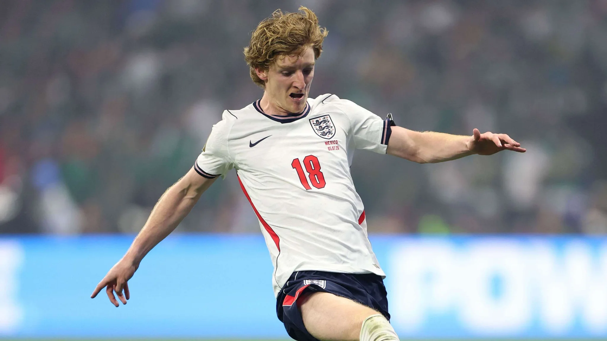 لاعب كرة قدم إنجليزي يرتدي قميص منتخب إنجلترا رقم 18 يتحكم بالكرة خلال مباراة في كأس العالم، مع التركيز على الأداء الدفاعي والهجومي.