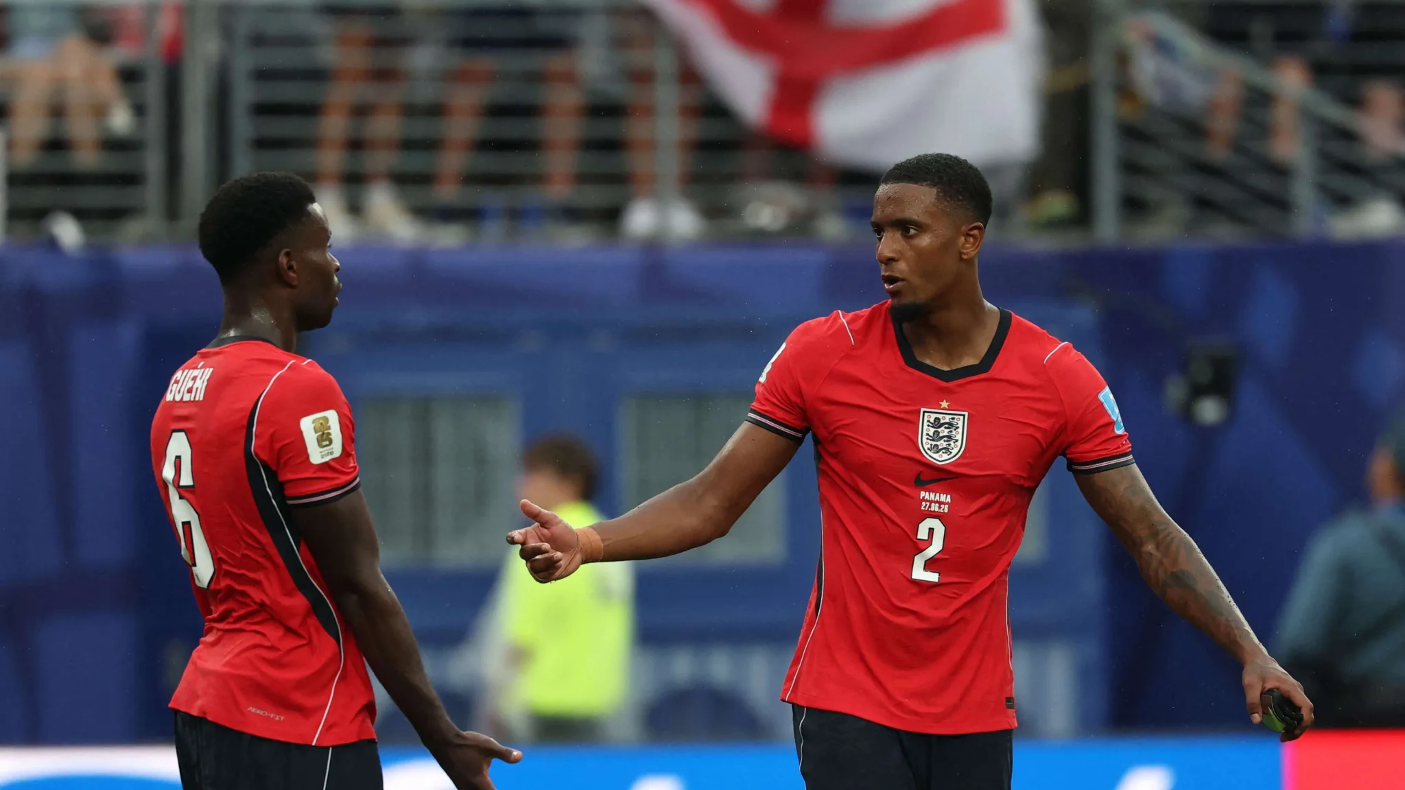 لاعبا منتخب إنجلترا يرتديان القميص الأحمر يتبادلان الحديث خلال مباراة في كأس العالم، مع تركيز على استعداد الفريق لمواجهة الأرجنتين.