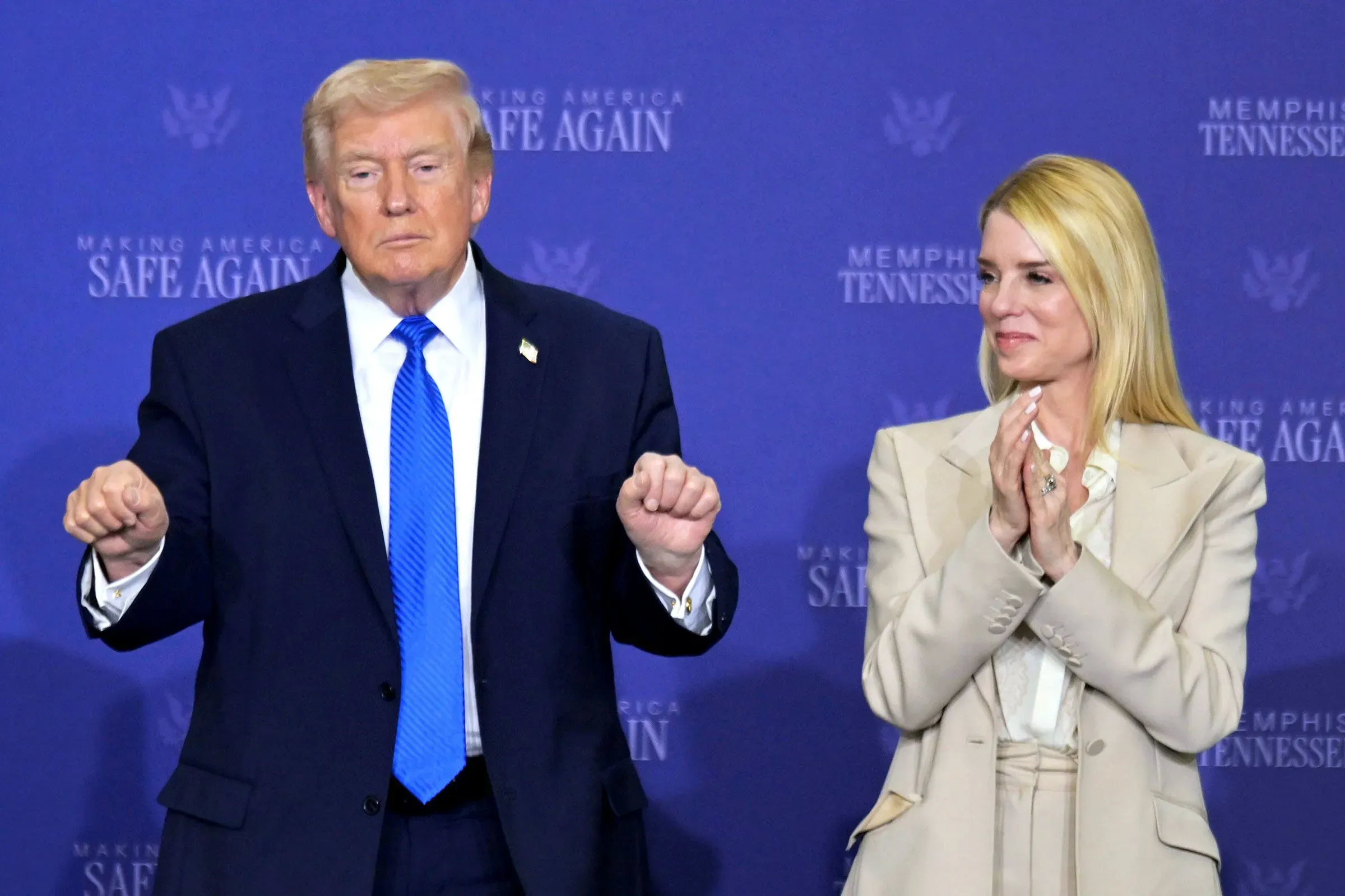 بام بوندي، المدعي العام السابق، تقف بجانب دونالد ترامب خلال خطاب في تينيسي، تعبيرات وجوههم تعكس الأجواء السياسية المتوترة.