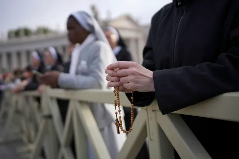 نساء يرتدين الزي الديني في ساحة الفاتيكان، يحملن مسبحة ويشاركن في حدث ديني، تعبيرًا عن دور المرأة المتزايد في الكنيسة.