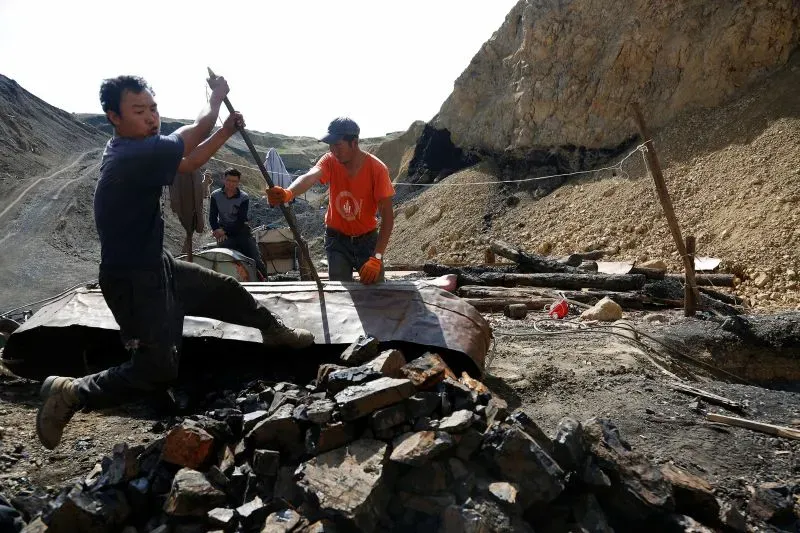 عمال في موقع تعدين في منغوليا، يعملون على استخراج الفحم، في سياق أزمة سياسية تتعلق بالفساد والتمييز الاجتماعي.