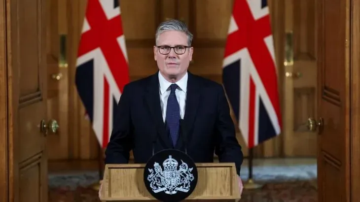 كير ستارمر، رئيس الوزراء البريطاني، يتحدث في مؤتمر صحفي حول اعتراف المملكة المتحدة بدولة فلسطين، مع العلم الوطني البريطاني خلفه.