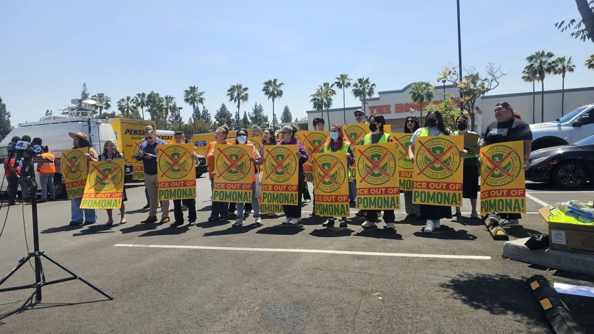 محتجون يحملون لافتات تطالب بإخراج ICE من بومونا، أثناء مؤتمر صحفي حول اعتقالات العمال المياومين.