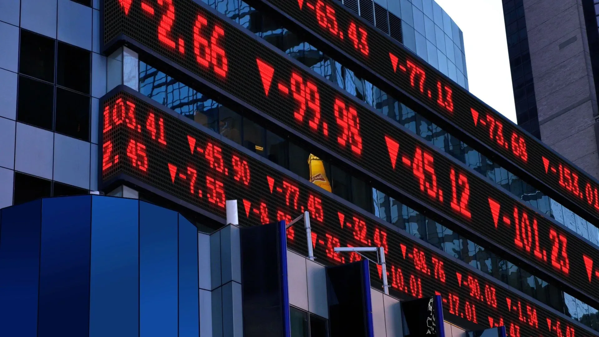 شاشة تعرض أسعار الأسهم باللون الأحمر، مع تراجع مؤشرات السوق الأمريكية مثل ستاندرد آند بورز 500، مما يعكس تقلبات السوق الحالية.