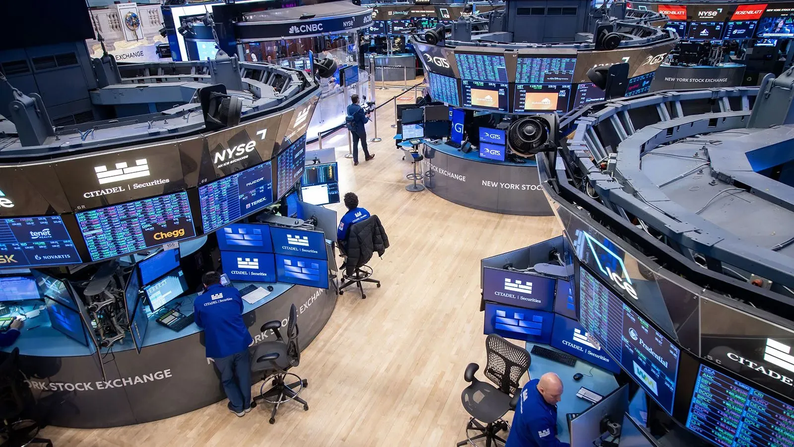 صورة تظهر قاعة تداول بورصة نيويورك، مع شاشات تعرض بيانات السوق والمستثمرين يعملون وسط أجواء من التوتر الاقتصادي.