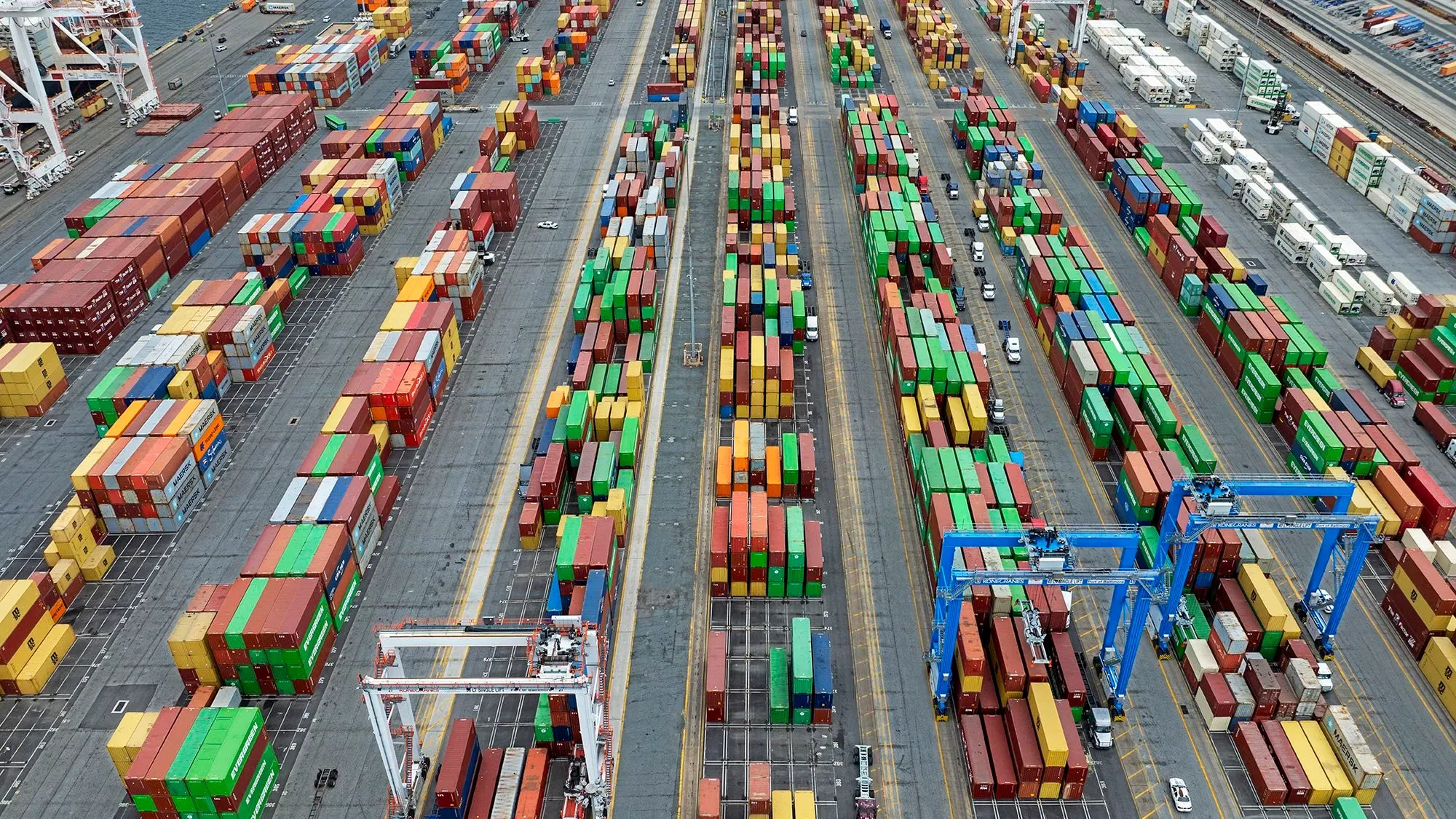 صورة لميناء يحتوي على حاويات شحن ملونة مرتبة بشكل منظم، تعكس تأثير التعريفات الجمركية على الاقتصاد الأمريكي.