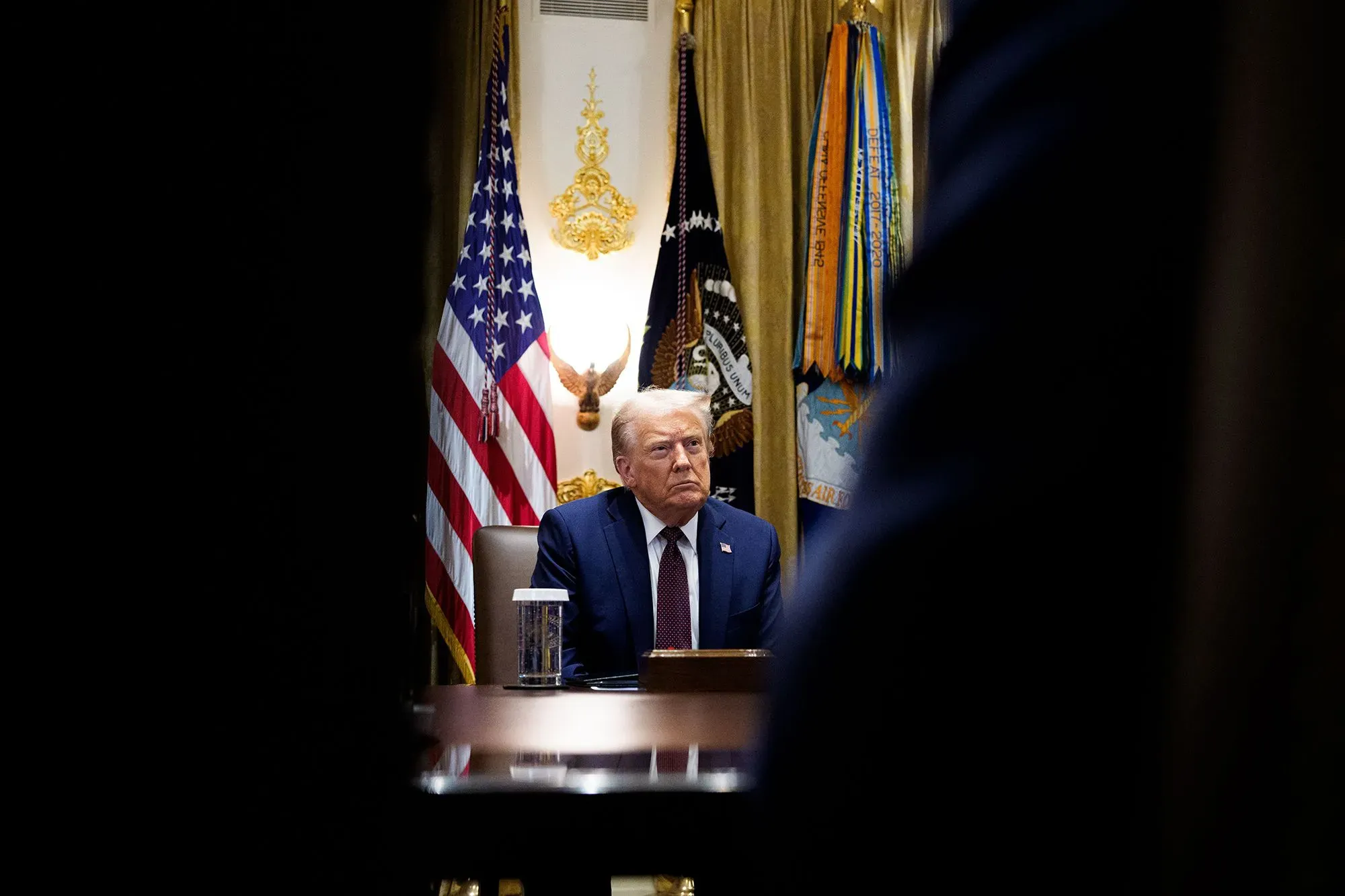 ترامب يجلس في اجتماع مجلس الوزراء مع العلم الأمريكي خلفه، معبرًا عن قلقه بشأن تغييرات محتملة في مجلس الاحتياطي الفيدرالي.