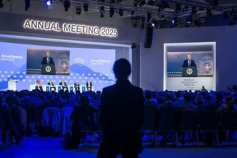 اجتماع سنوي في منتدى دافوس الاقتصادي 2025، حيث يتحدث دونالد ترامب على المسرح، مع جمهور كبير وأعضاء آخرين في القاعة.
