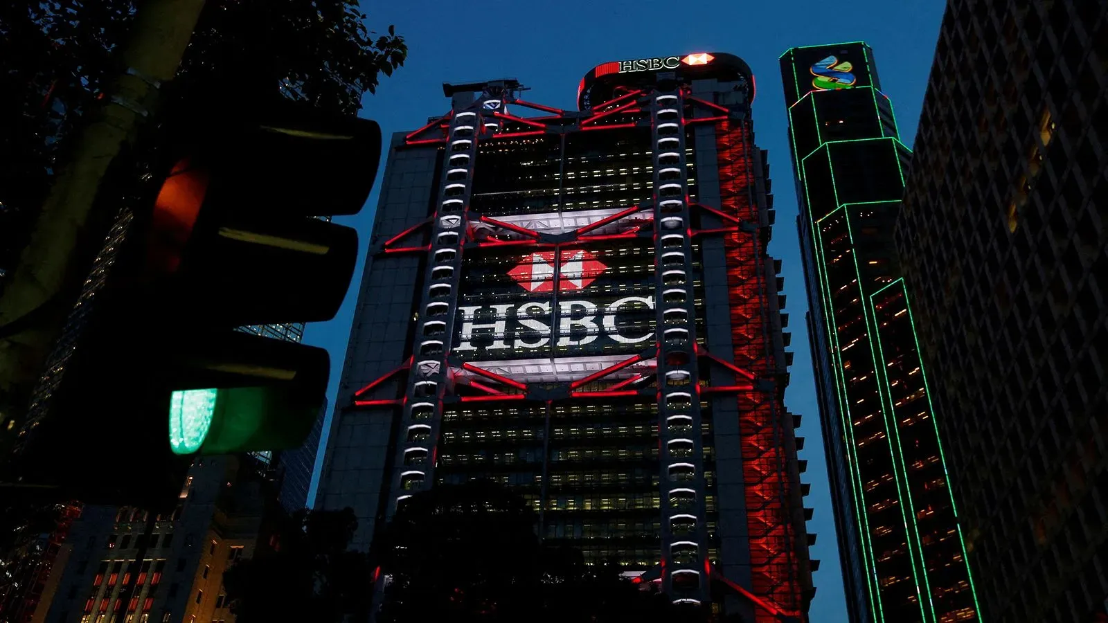 مبنى بنك HSBC مضاء ليلاً في هونغ كونغ، مع إشارة مرور خضراء، مما يعكس تركيز البنك على السوق الآسيوية وتعزيز العوائد.