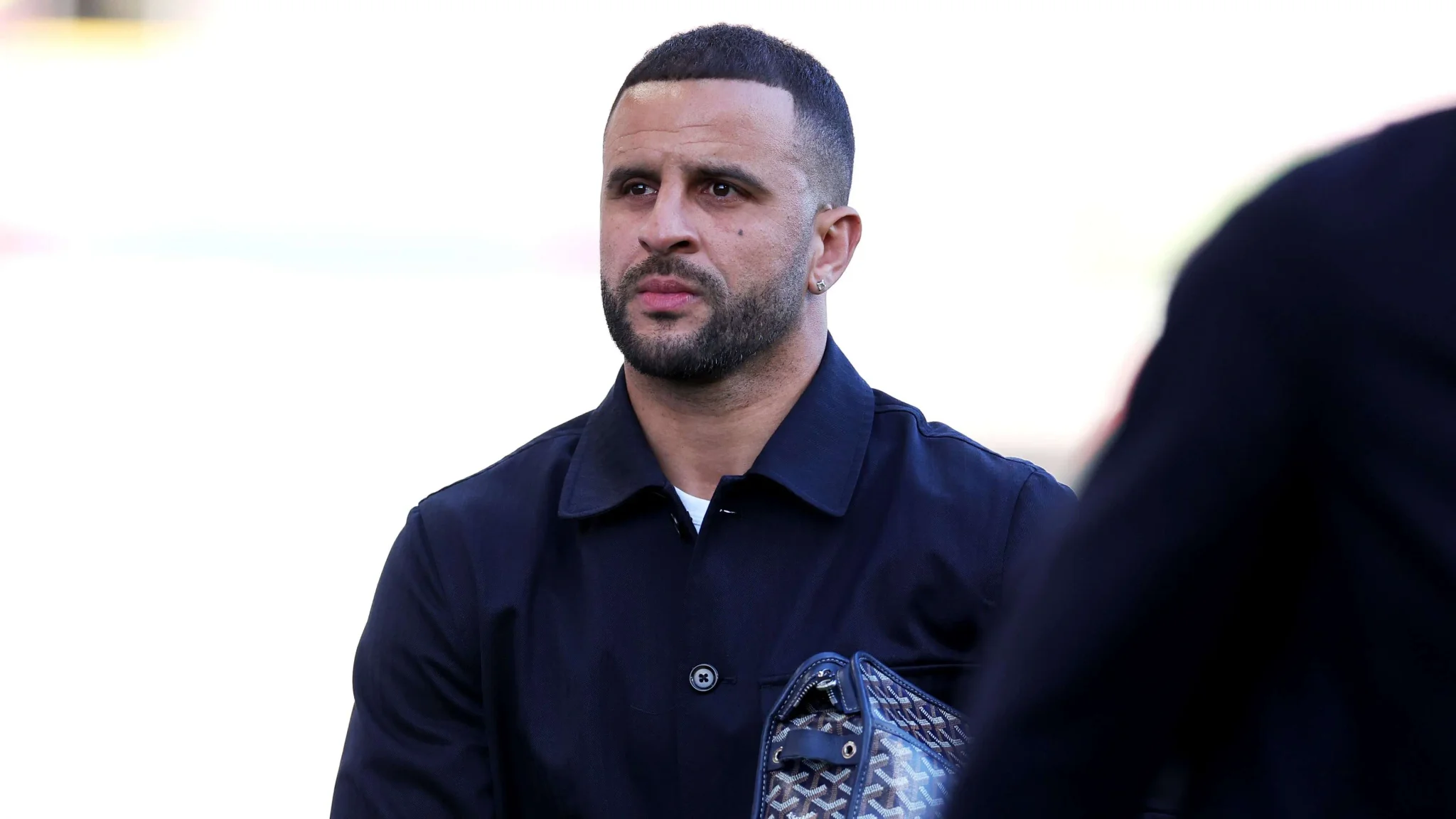 كايل ووكر لاعب كرة قدم يرتدي معطفًا أسود، يستعد لخوض تجربة جديدة في دوري الدرجة الأولى الإنجليزية مع نادي بيرنلي بعد هبوط الفريق من الدوري الممتاز.