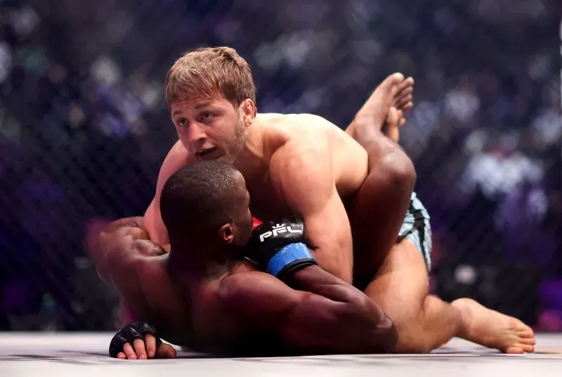 إبراغيم إبراغيموف في نزال فنون القتال المختلطة، يتفوق على خصمه كيني موخونوانا، مع التركيز على مهاراته القتالية والتدريب المكثف.