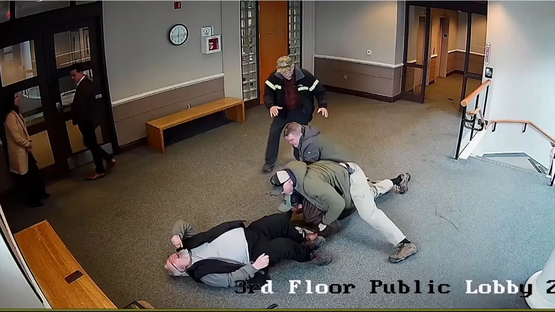 اعتقال ويلسون مارتيل-ليبرون في قاعة المحكمة ببوسطن، حيث يظهر أربعة رجال يسيطرون عليه بينما يُكبّل.