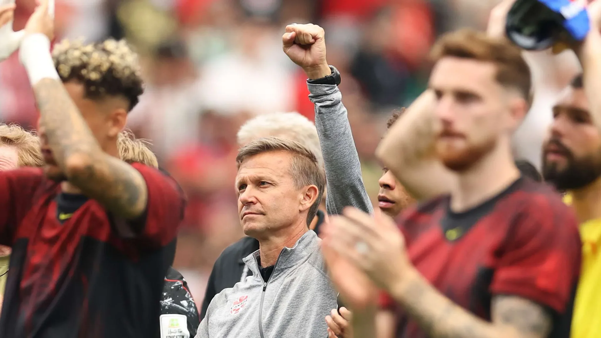 المدرب جيسي مارش يرفع يده بتصميم وسط لاعبي منتخب كندا بعد مباراة كأس العالم ضد المغرب، معبرًا عن الفخر رغم الخسارة.
