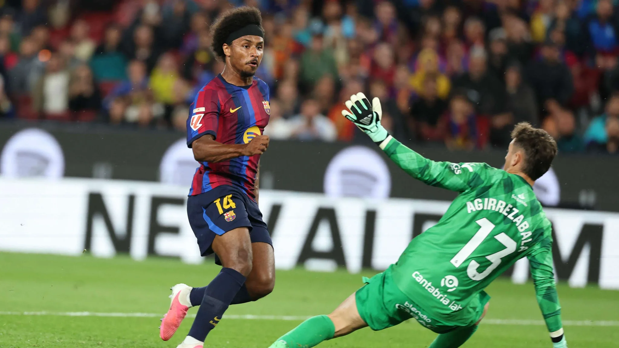 كريم أديمي لاعب برشلونة يراوغ حارس مرمى فريق رايسينغ سانتاندير خلال مباراة حاسمة في الدوري الإسباني.