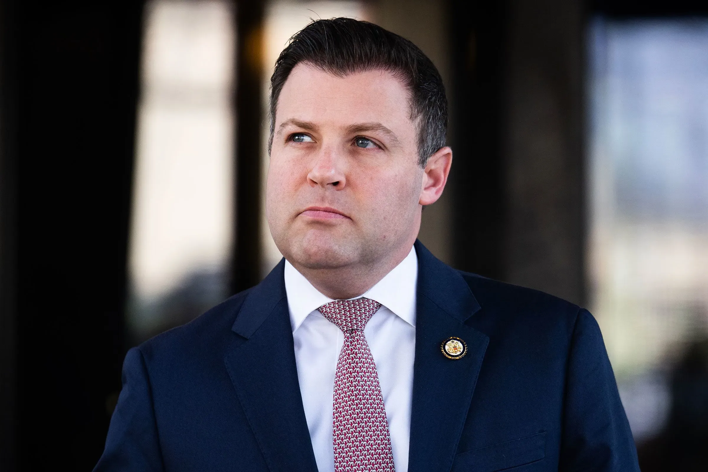 رجل يرتدي بدلة رسمية، ينظر إلى الأمام بتعبير جاد، في سياق مناقشة قضايا رعاية الأطفال وتكاليفها المرتفعة.