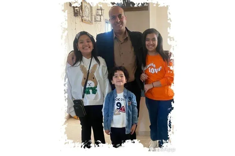 عائلة تتكون من أب وثلاثة أطفال في منزلهم، يعبرون عن الحب والترابط وسط ظروف صعبة بسبب النزاع في غزة.