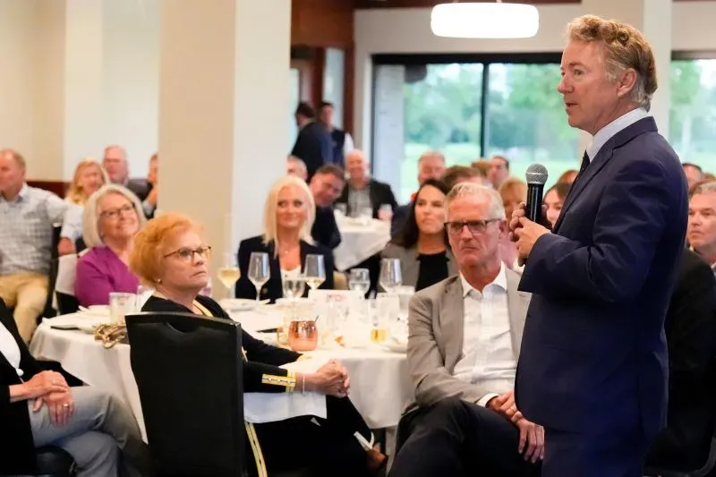 راند بول يتحدث خلال حفل لجمع التبرعات في أيوا، بينما يستمع له جمهور من الجمهوريين في قاعة مخصصة.