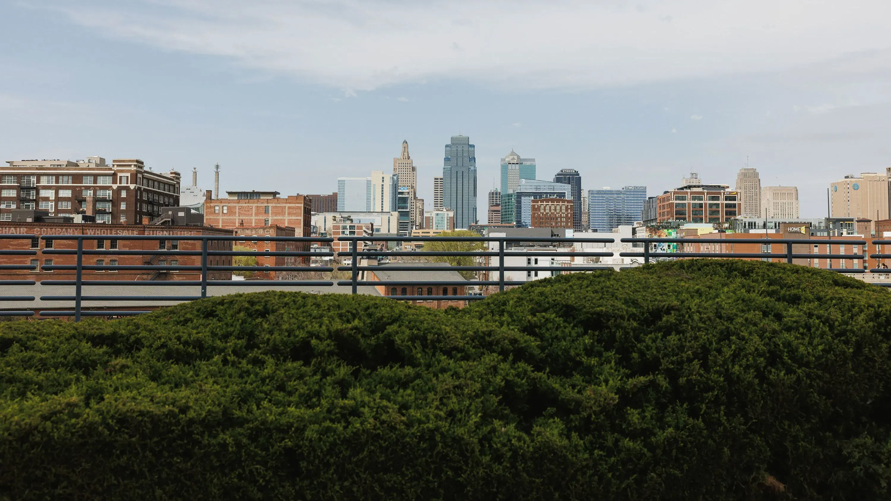 منظر لمدينة كانساس سيتي يظهر الأفق مع المباني الشاهقة، محاطًا بالأشجار، مما يعكس تأثير التوظيف الفيدرالي على الاقتصاد المحلي.