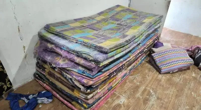 صورة لعدد من الفُرُش المتراكمة في غرفة، تشير إلى ظروف معيشية سيئة للأطفال الذين تم إنقاذهم من دور الرعاية التابعة لشركة GISBH.