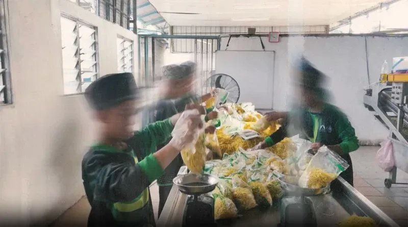 أطفال يعملون في مصنع لتعبئة الطعام، مع وجود أكياس مملوءة بالمكرونة، في سياق تحقيقات حول انتهاكات حقوق الإنسان في دور الرعاية.