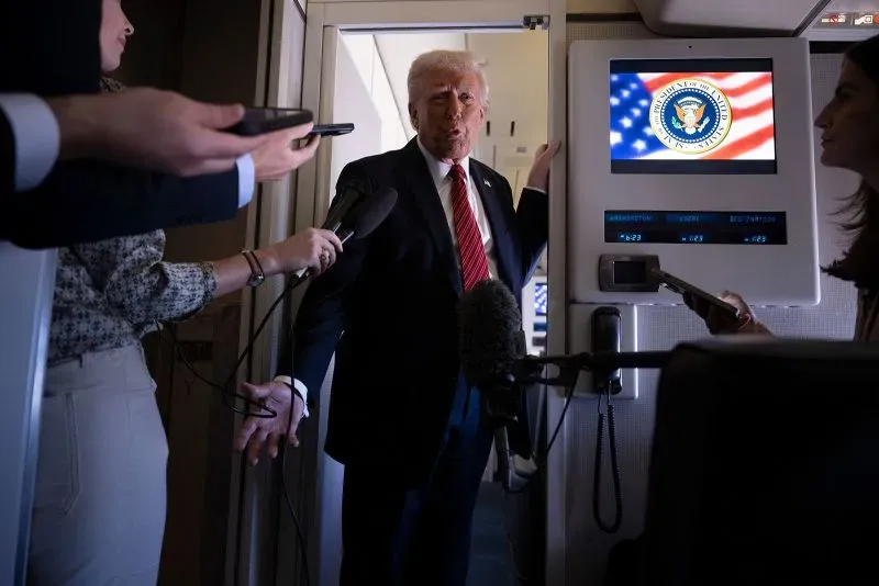 ترامب يتحدث للصحفيين داخل الطائرة الرئاسية، مع شعار الرئاسة الأمريكية خلفه، وسط تساؤلات حول الوضع في أوكرانيا.