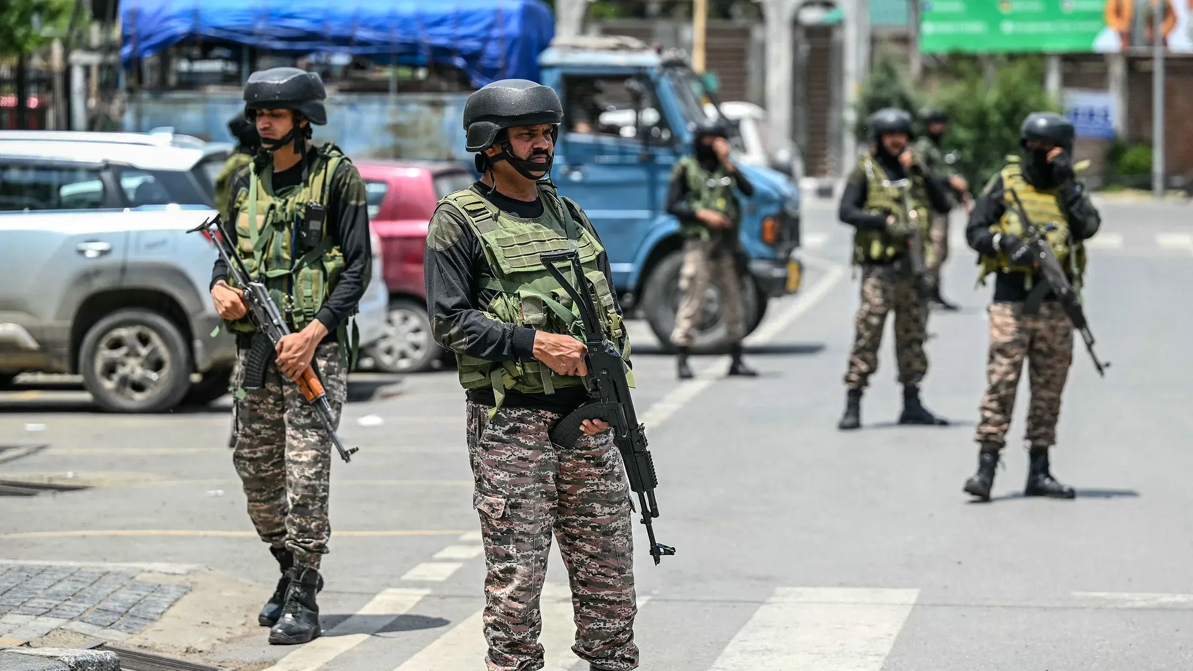 جنود مسلحون في حالة تأهب، يقفون في شارع مزدحم، وسط توتر أمني بعد الصراع بين الهند وباكستان، مع سيارات خلفهم.